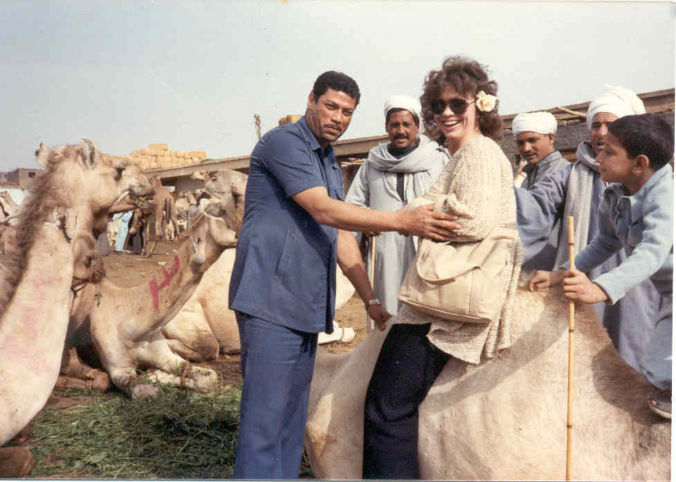 photograph portrays a confident tourist sitting on
a kneeling camel attended by amused natives.